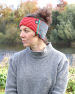 Lifestyle shot of a lady wearing a red and pink patterned headband beside the river.