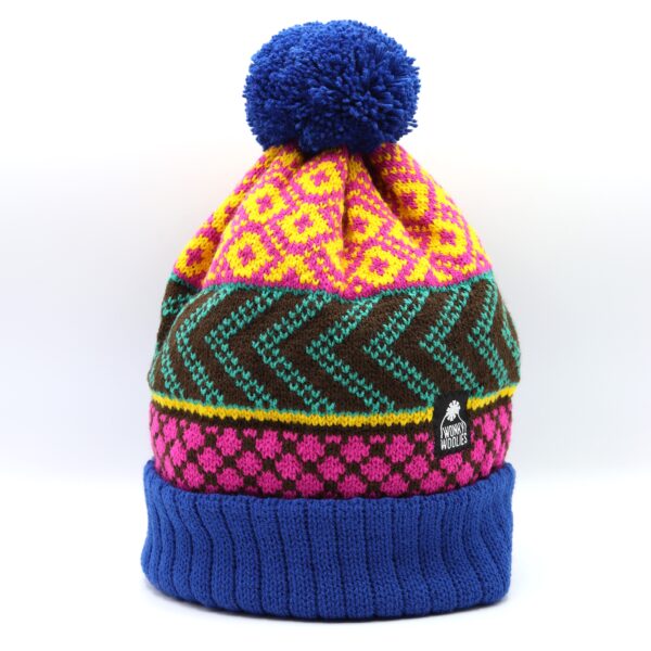 The original Wonky hat, knitted in royal blue, pink, yellow, jade and brown. A royal blue turn up and pompom border the pattern area.