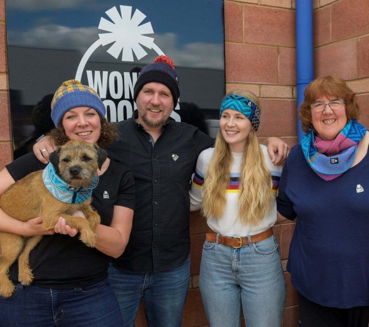 Staff photo in front of company logo