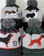 Image of four hats with dogs knitted onto them, a boxer dog, a rottweiler, a springer spaniel and a border collie dog.