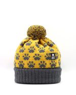 Product shot of a pompom hat with a paw print pattern knitted into it. The hat turn up is charcoal grey with the main hat being mustard with grey paw prints.
